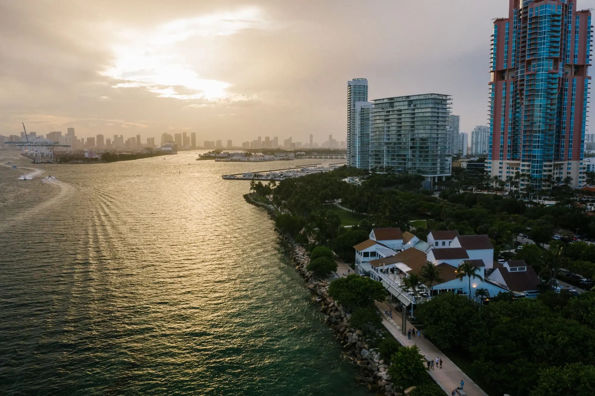 A bay shoreline lined with towers, seen from the air at sunset