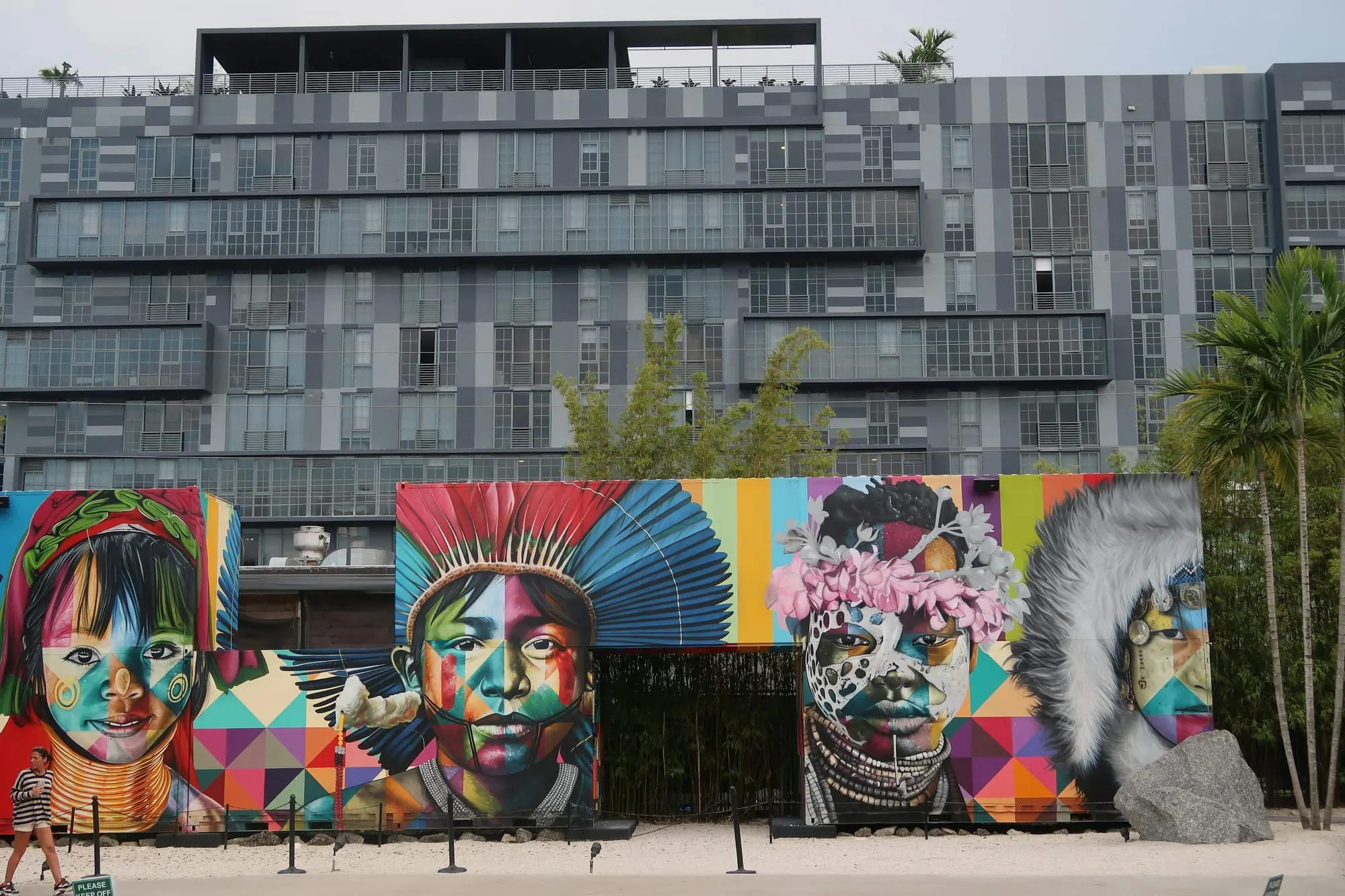 A building with a facade covered in large murals, seen from street level