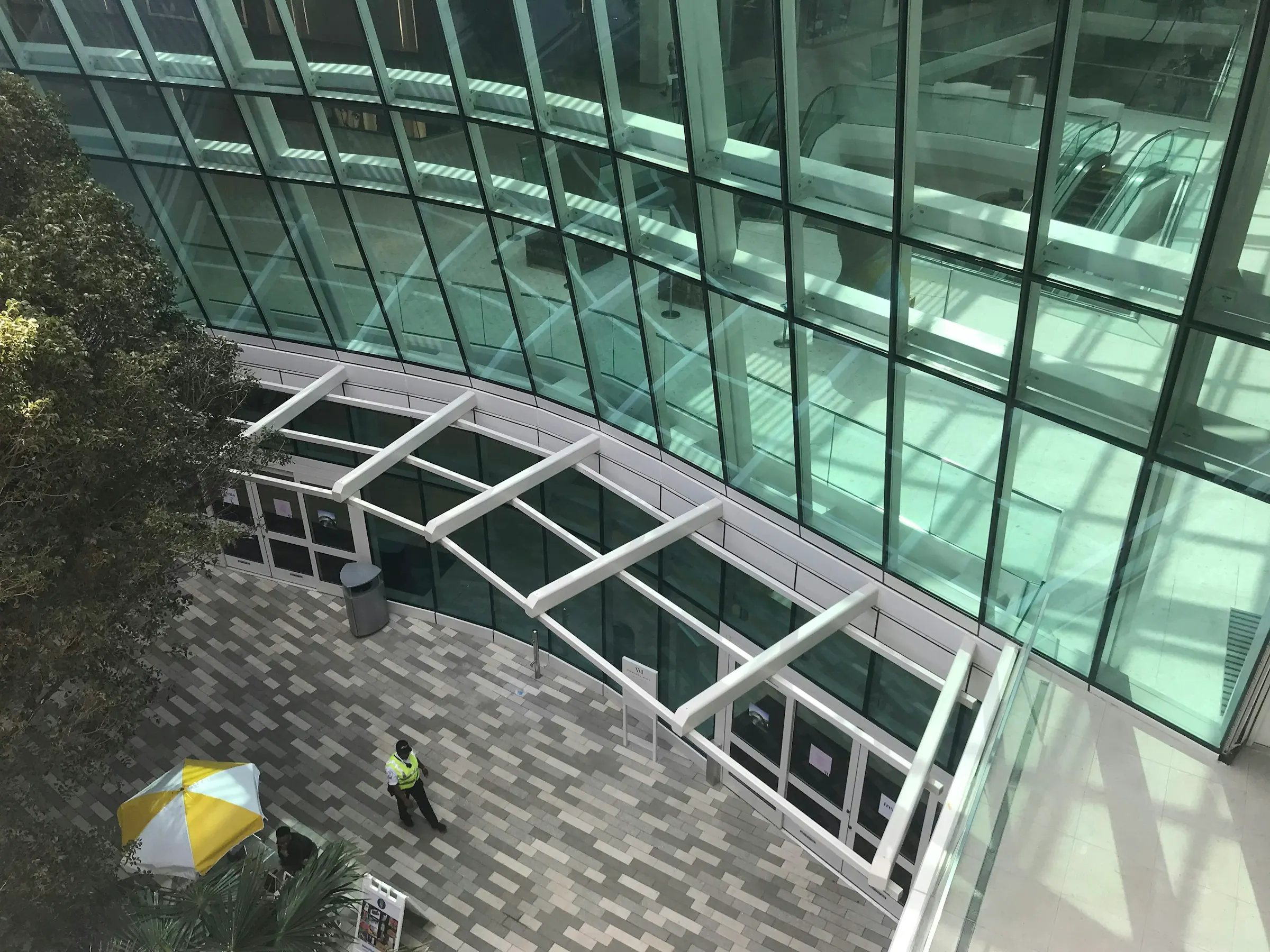 Bir alışveriş merkezinin kavisli camlı girişi, kuş bakışı